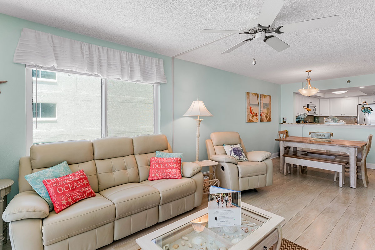 Relax in your bright, coastal-themed living space with comfy leather seating, ocean-inspired decor, and an open kitchen.