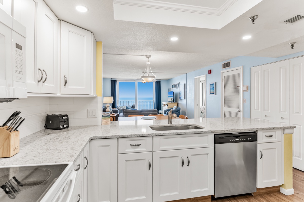 Step into your bright, fully-equipped kitchen where cooking feels effortless with granite countertops, stainless appliances, and that stunning ocean view inviting you to start your day.