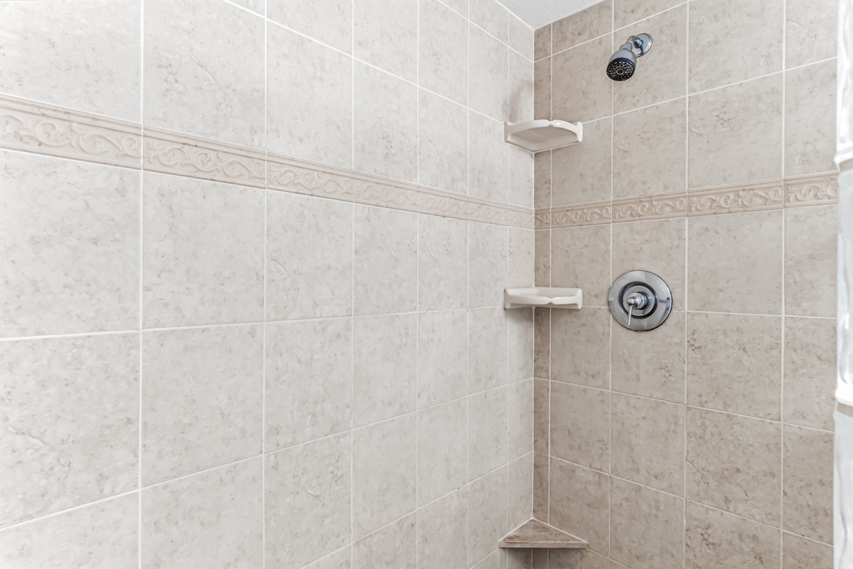 Your private shower features elegant tile work, built-in corner shelves for your toiletries, and a soothing rain-style showerhead to help you unwind.