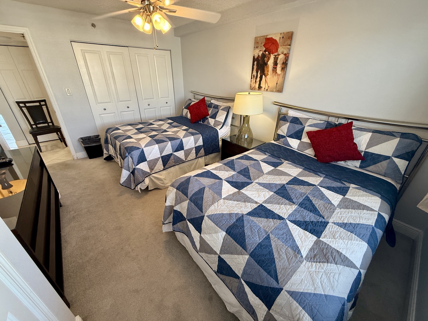 Your cozy bedroom features 2 double beds with stylish geometric bedding, a ceiling fan for comfort, and spacious closets for all your belongings.