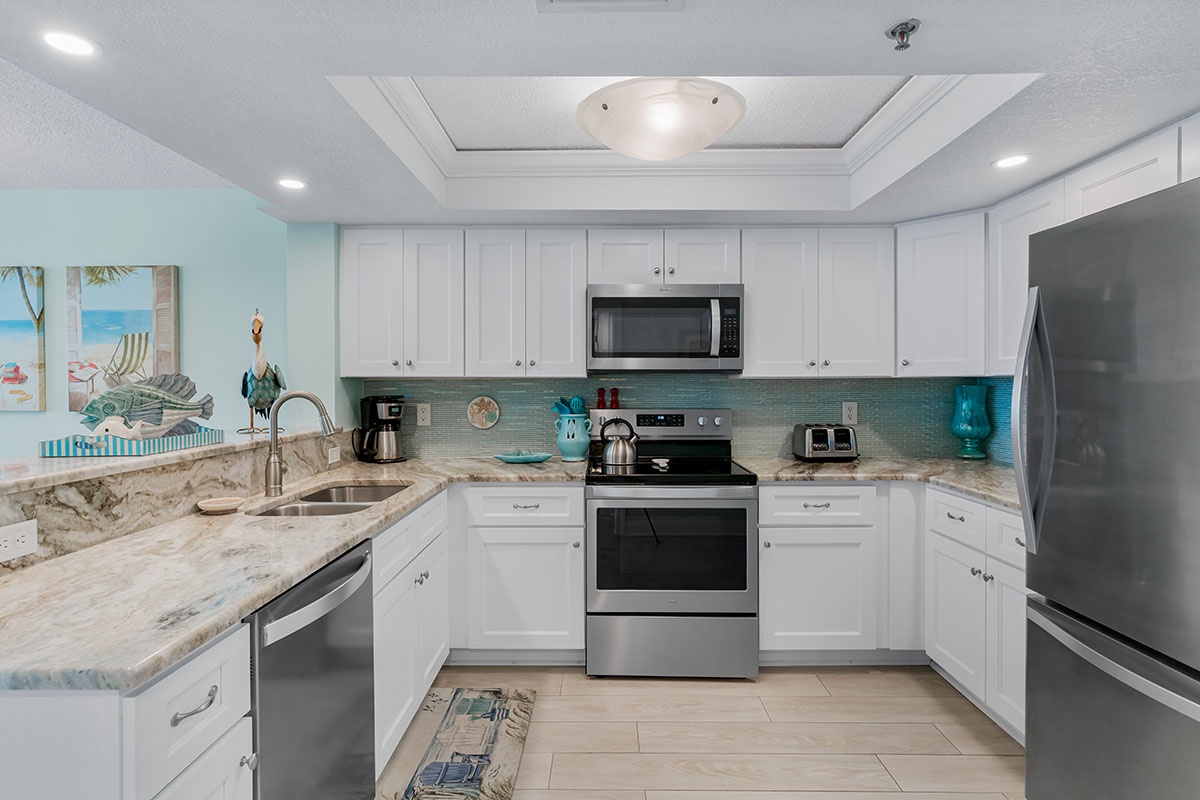 Cook your favorite meals in this fully-equipped kitchen with granite counters, stainless appliances, and bright coastal charm.