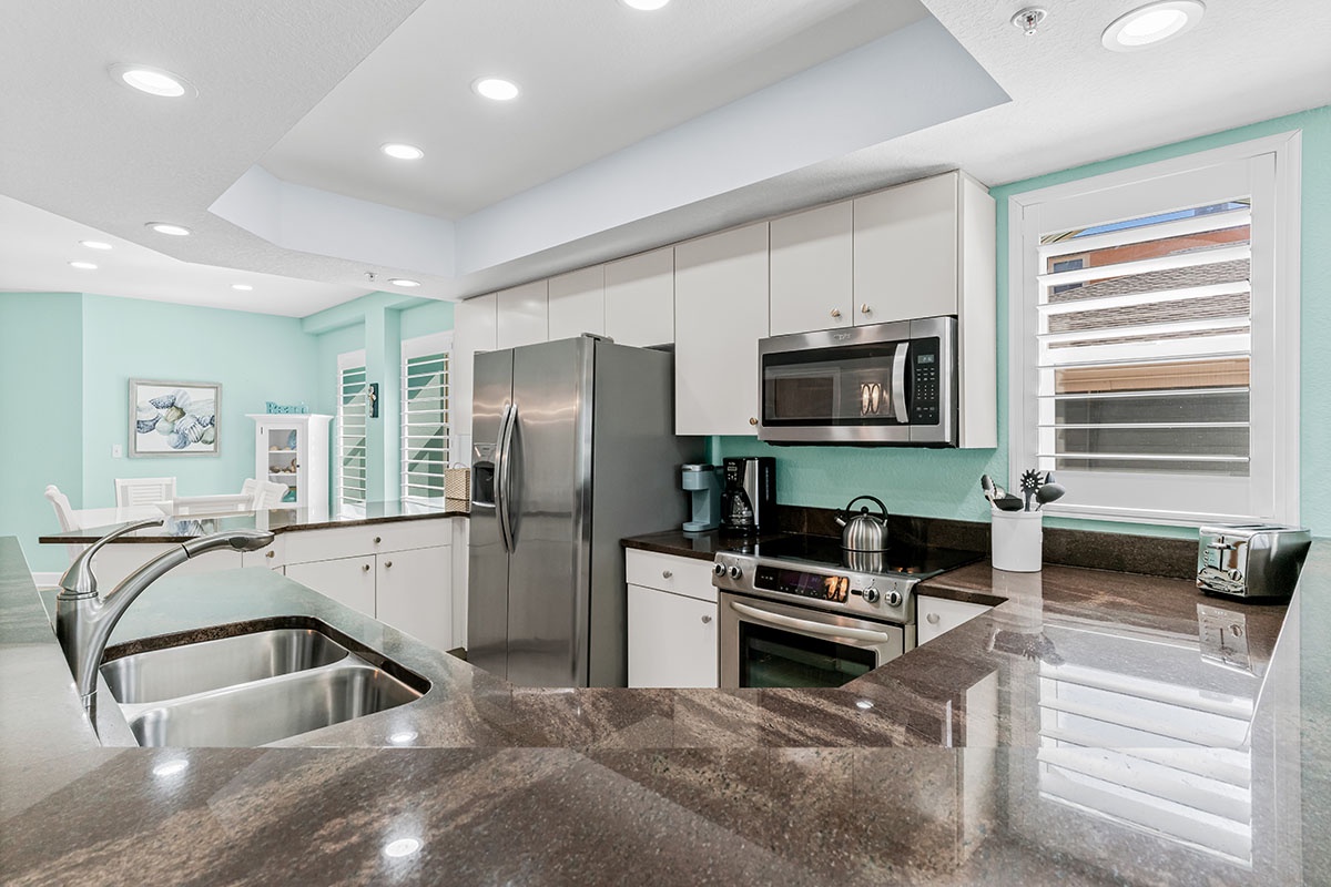 Your fully equipped gourmet kitchen features granite countertops, stainless steel appliances, and soothing coastal colors for effortless meal preparation.