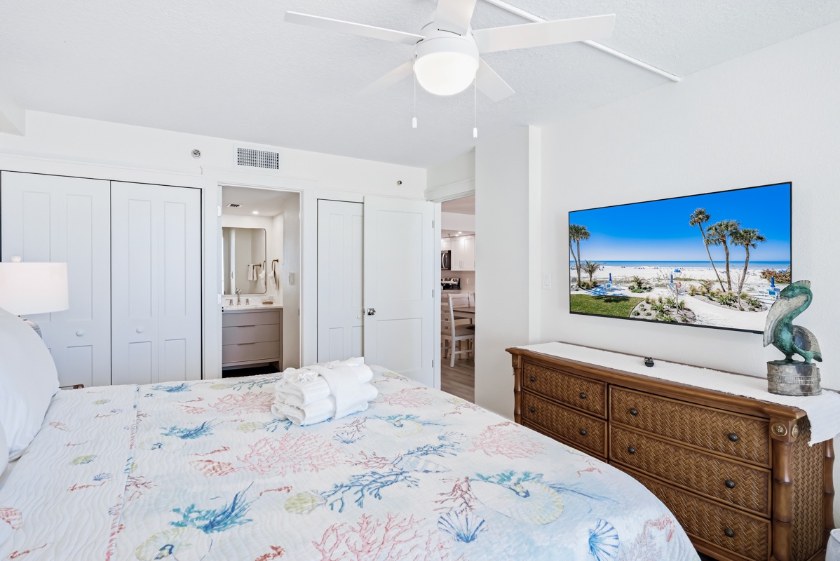 Unwind in your bright bedroom featuring tropical-inspired linens, coastal artwork, and modern amenities for the perfect beach getaway retreat.
