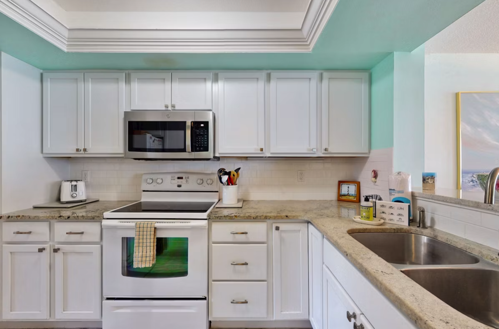 Your fully equipped kitchen features crisp white cabinetry, granite counters, and modern appliances—everything you need to whip up a quick breakfast or a leisurely dinner during your stay.
