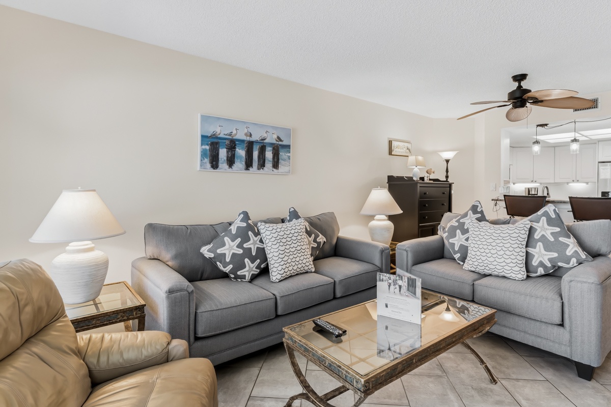 Sink into the plush seating and let the coastal vibes wash over you. This inviting living space features comfortable sofas adorned with starfish-themed pillows, perfect for unwinding after a day of beachside adventures.
