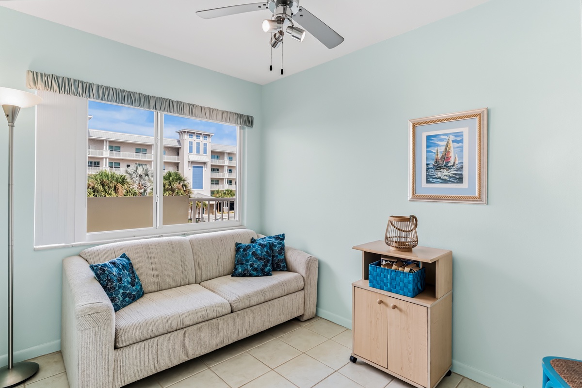 Relax in your cozy den sleeping room with soothing coastal blue tones, Queen Sleeper Sofa, and views of the surrounding neighborhood through large windows.