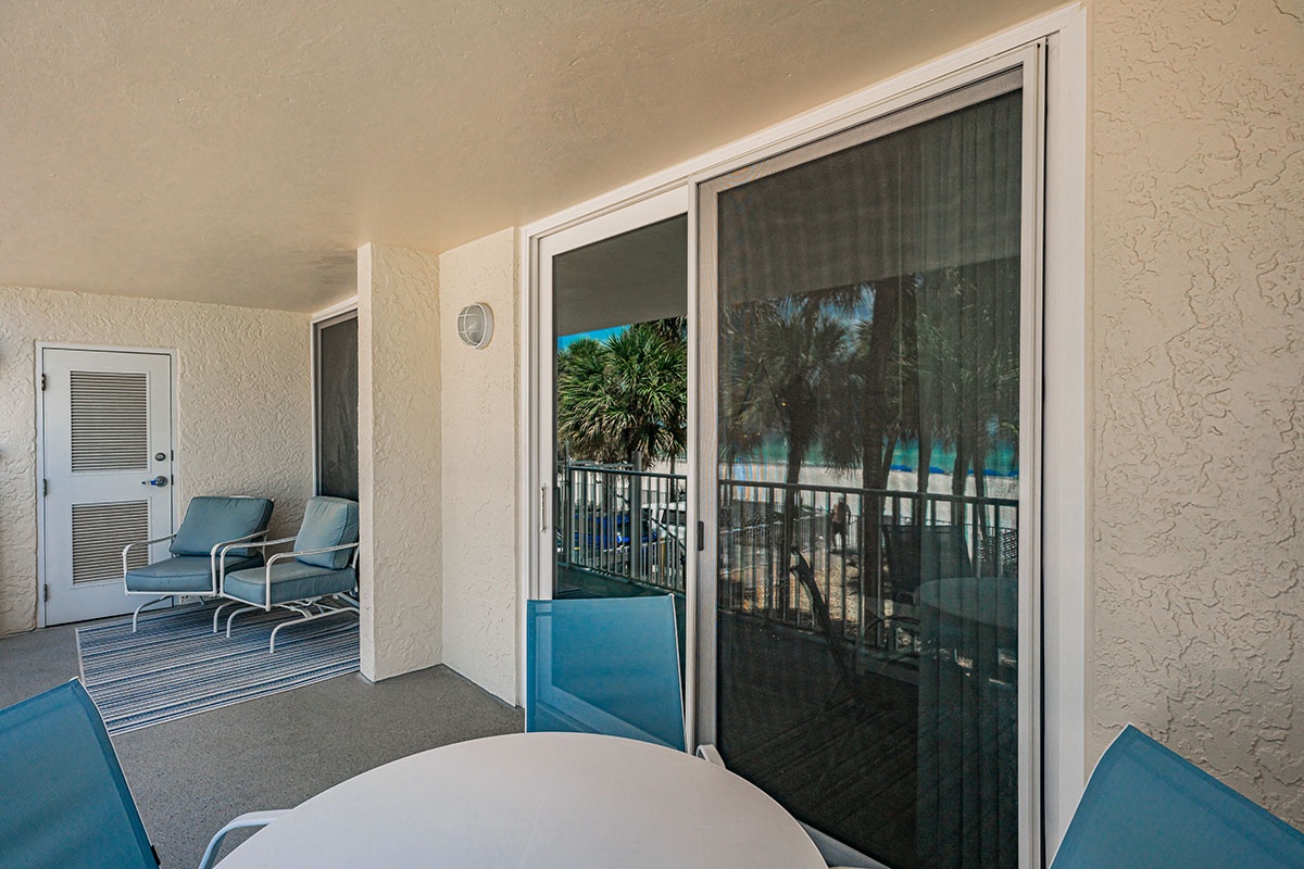 Step onto your private balcony where coastal breezes and ocean views await. Comfortable seating invites you to unwind while the tropical palms frame your perfect beachside escape.