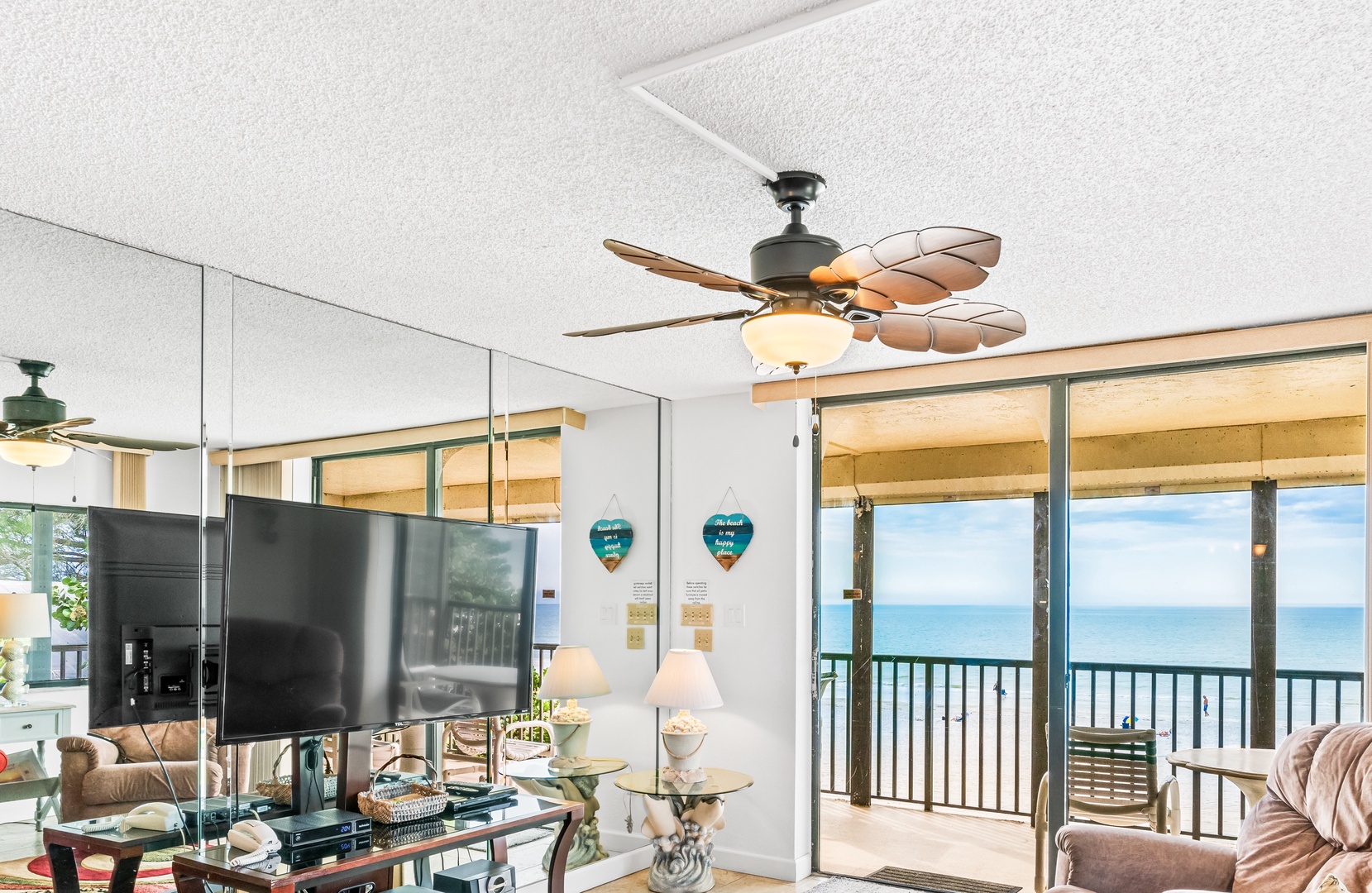Large TV in living room with ceiling fan