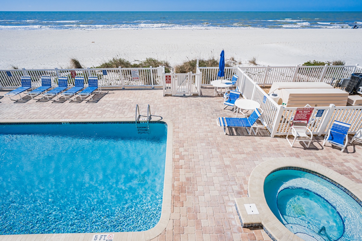 Beachfront pool deck with direct beach access and hot tub for the perfect coastal getaway.