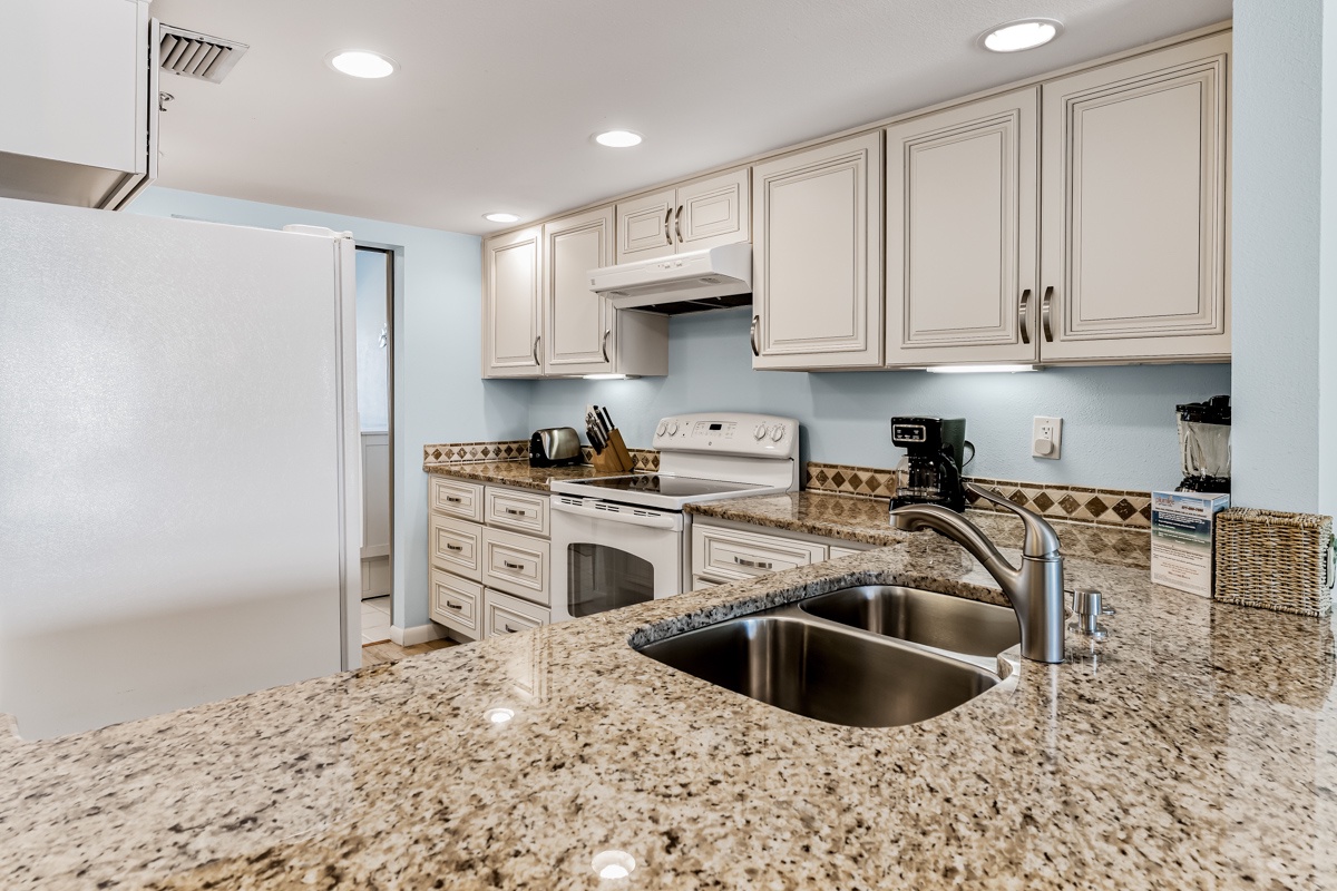 Your fully equipped kitchen awaits with granite counters, modern appliances, and ample prep space—perfect for preparing morning coffee or a home-cooked meal during your stay.