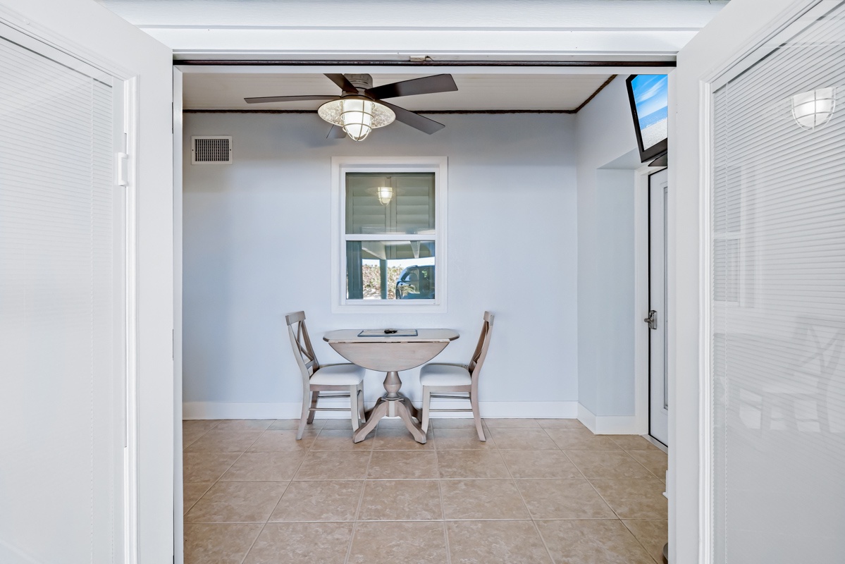 Enjoy intimate meals at your charming dining nook, where soft blue walls and warm natural light create the perfect morning atmosphere.