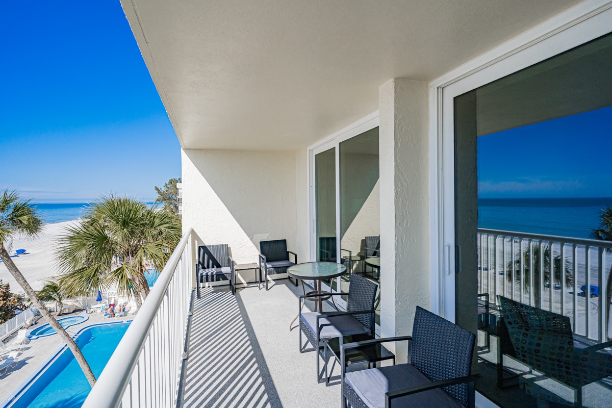 Unwind on your private balcony with comfortable seating while taking in stunning ocean views and resort amenities below.