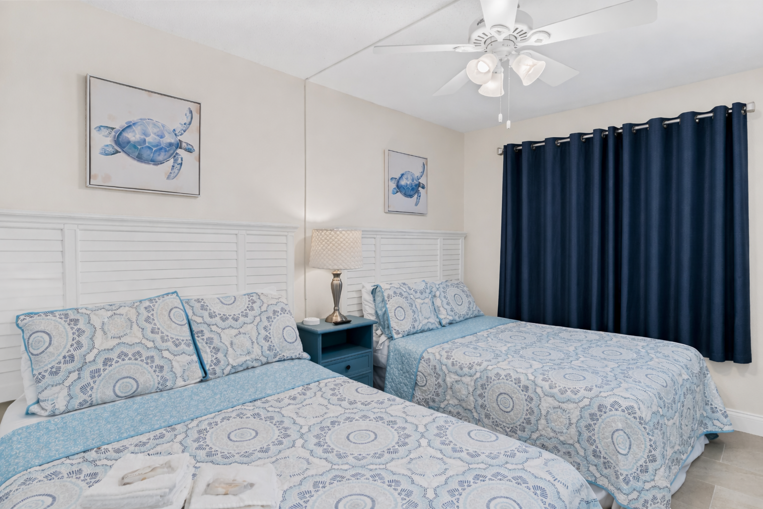 Rest peacefully in your coastal-themed Queen bedroom, where soothing blue tones and sea turtle artwork create a serene oceanside retreat.