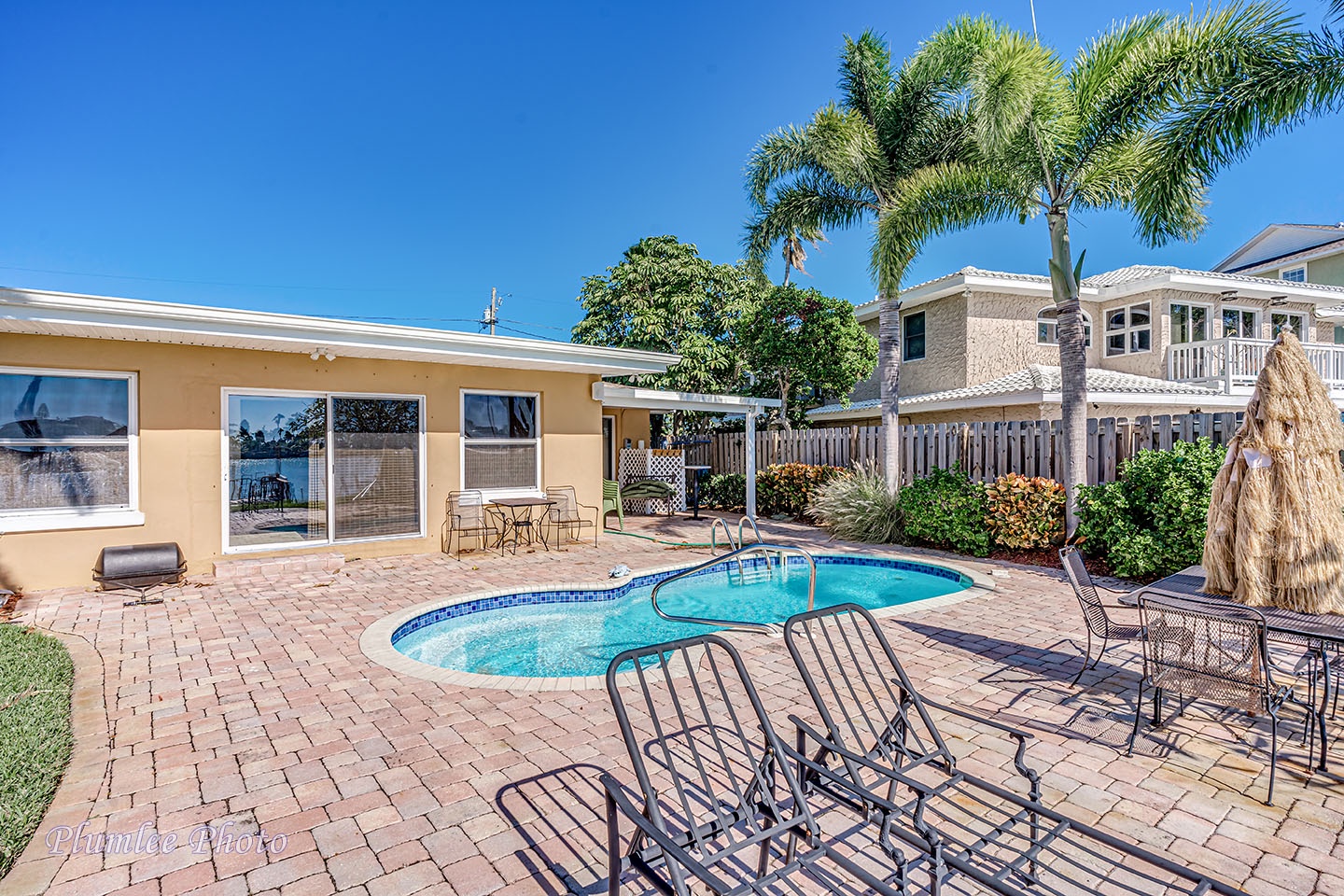 Paved deck around pool with loungers