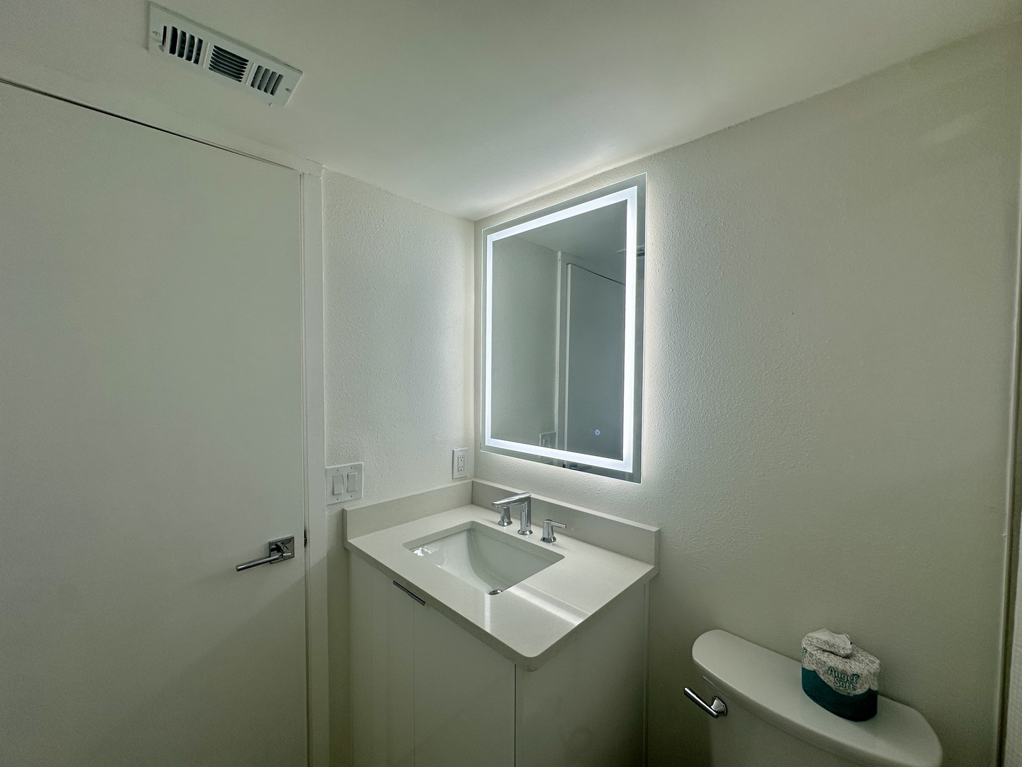 Modern lighted mirror in hallway bathroom