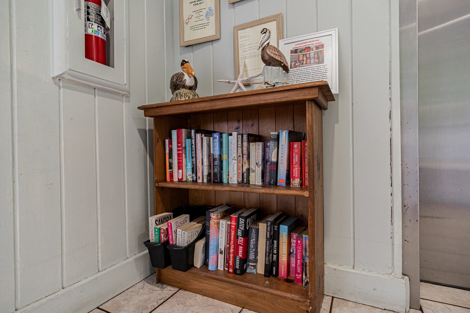 Curl up with a good read from the curated bookshelf, where thoughtful touches—like coastal bird decor and framed local lore—invite you to unwind and connect with the area's charm.