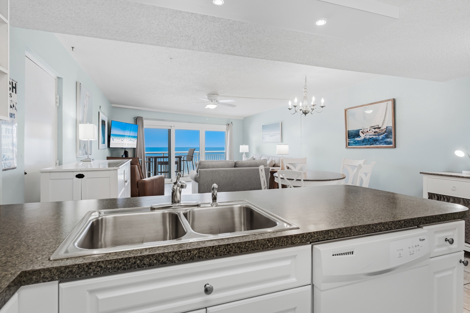 Step into your bright, open-concept space where the kitchen flows effortlessly into the living and dining areas. That stunning ocean view through your glass doors sets the scene for mornings with coffee and evenings watching the waves.