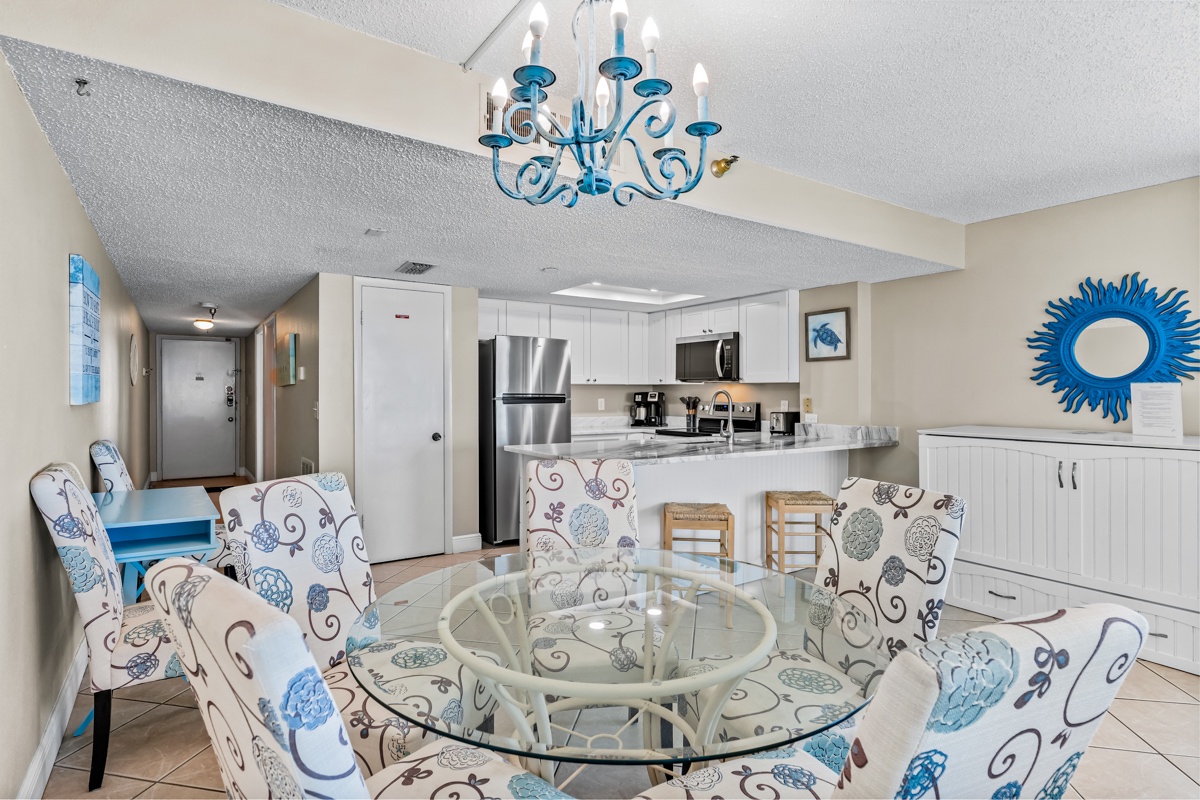 Relax in your bright coastal retreat with elegant chandelier, modern kitchen, and comfortable dining for memorable meals together.