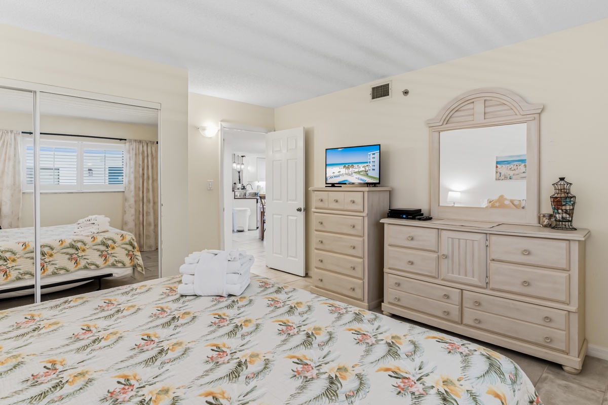 Relax in your bright, coastal-themed bedroom with ample storage and beach-inspired decor. Comfortable linens, a spacious layout, and convenient access to your en-suite bathroom create the perfect retreat after a day of adventure.