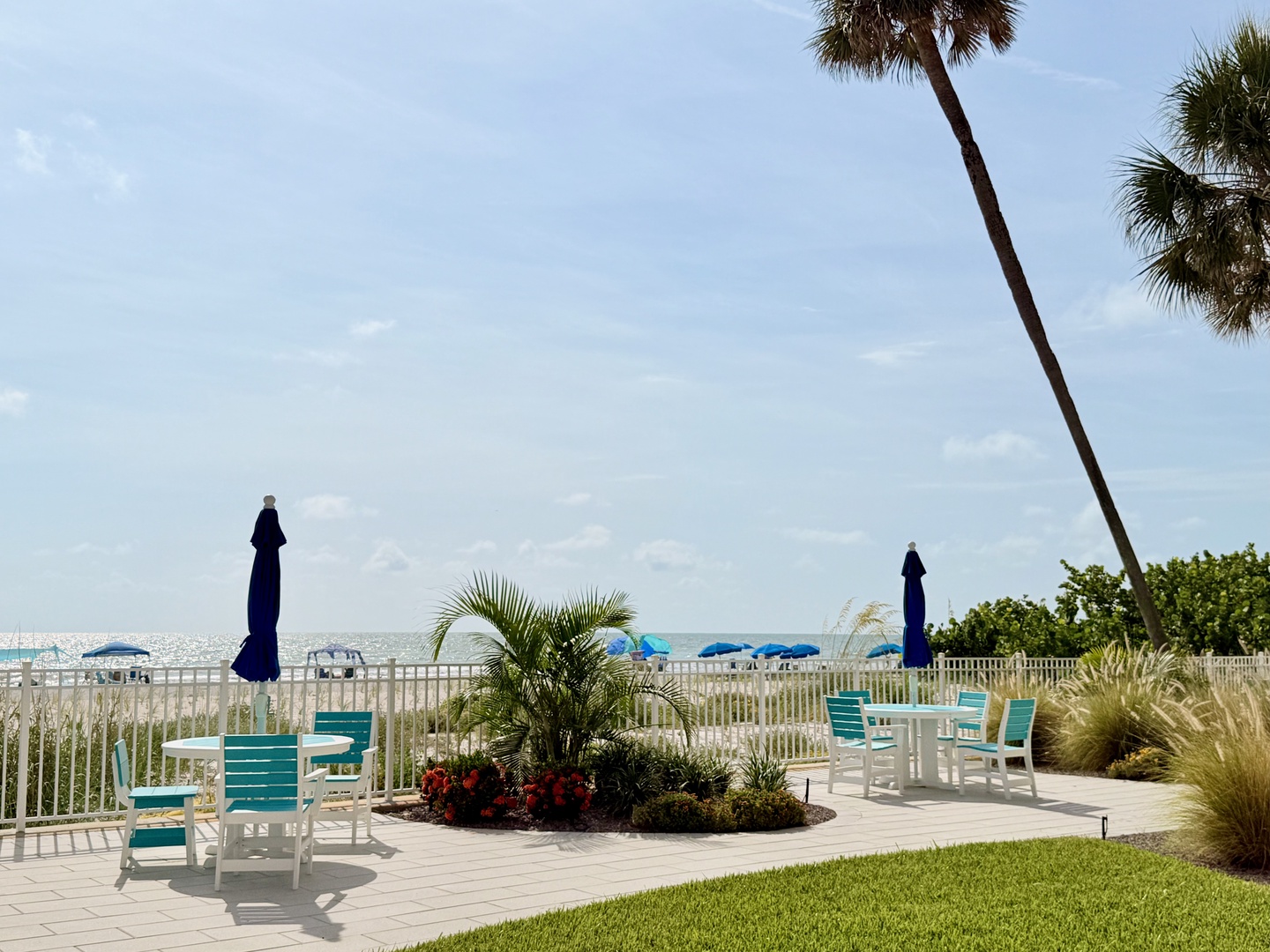 A beachfront patio with loungers and palm trees offers easy access to white sands and calm Gulf waters, perfect for your coastal retreat.