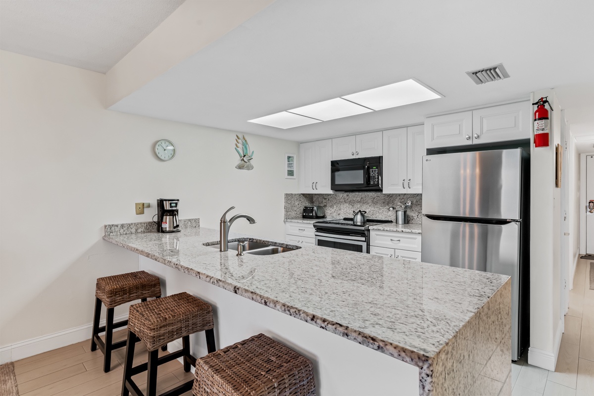 Your bright, fully-equipped kitchen awaits with granite counters, stainless steel appliances, and breakfast bar seating for casual dining.