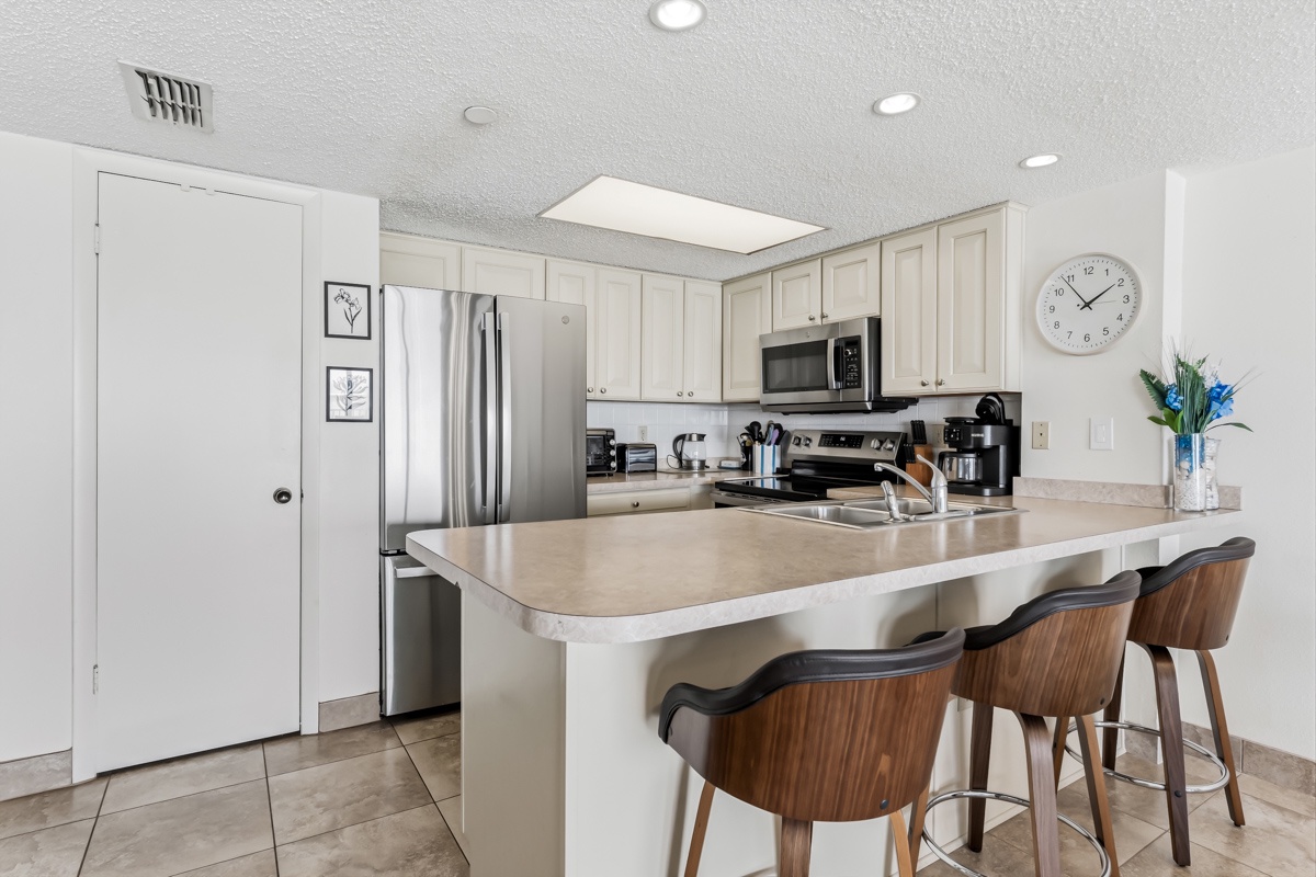 Step into your fully equipped kitchen with modern stainless steel appliances, plenty of counter space, and comfortable seating at the breakfast bar—perfect for whipping up your morning coffee or enjoying a relaxed meal together.