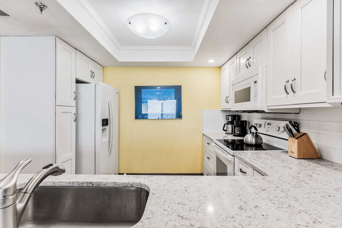 Step into your fully equipped kitchen with gleaming granite counters, white cabinetry, and modern appliances ready for your culinary adventures. Bright, cheerful, and stocked with everything you need.