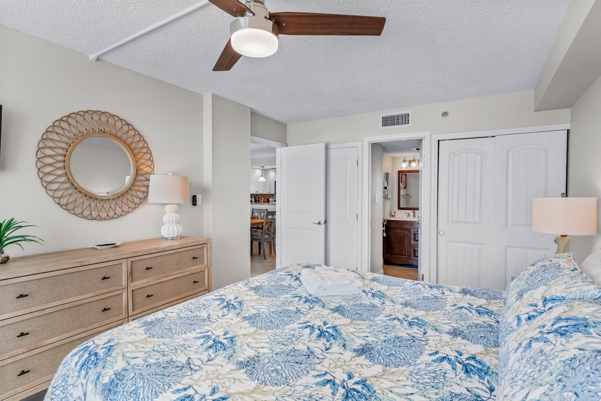 Your coastal bedroom offers serene comfort with blue-patterned linens and warm wood accents, perfect for restful nights after beach days.