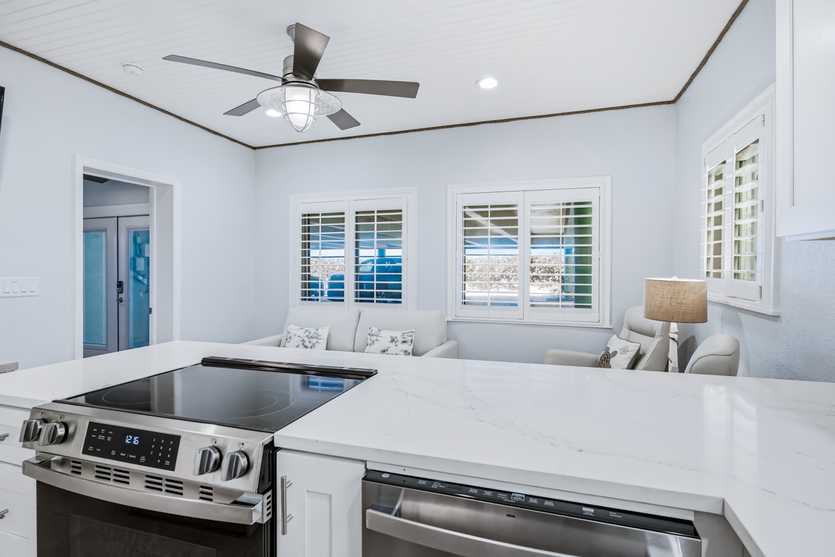 Your bright open-plan kitchen flows into a comfortable living space where you can cook, dine, and relax with ocean views through plantation shutters.