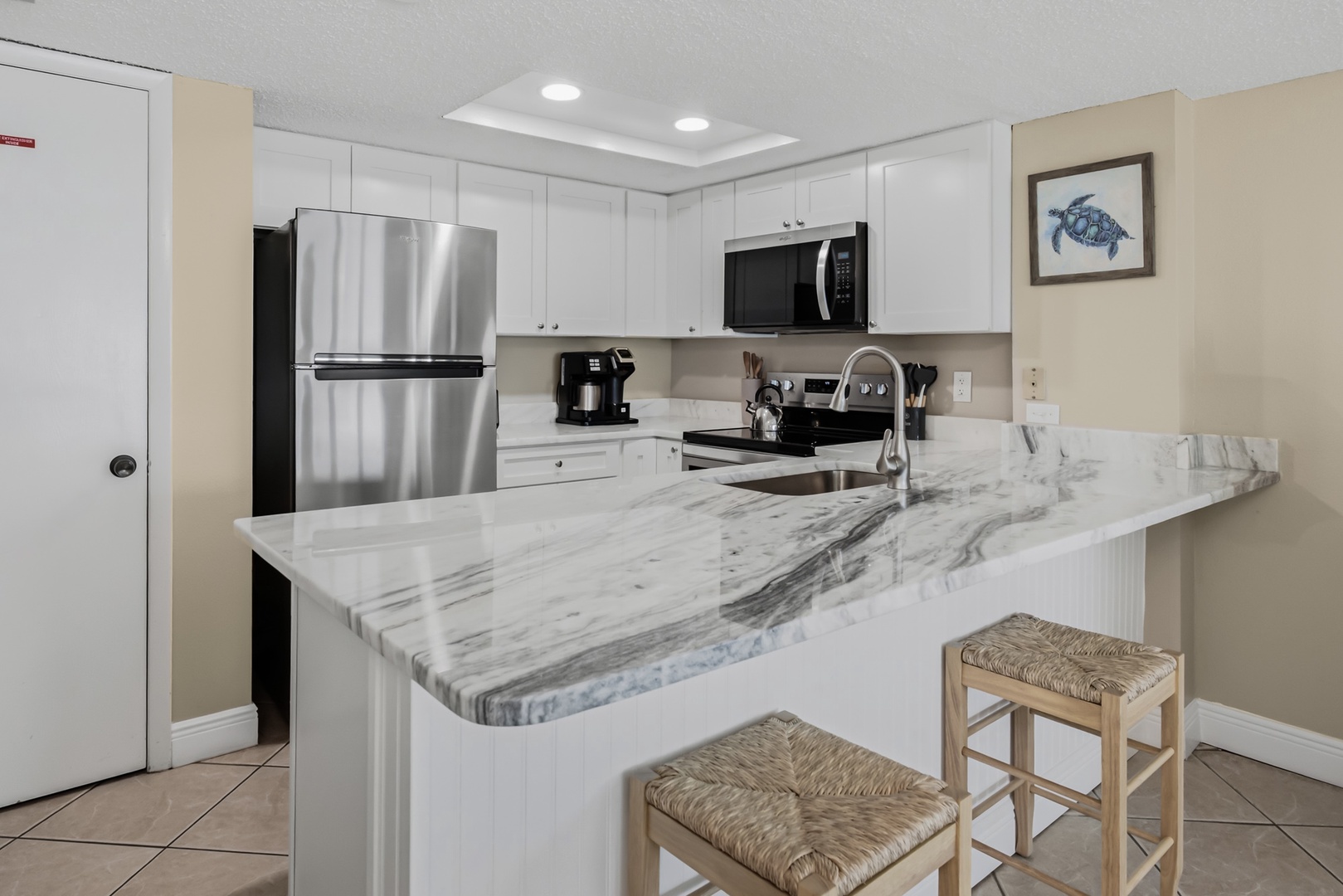 Your fully equipped kitchen features sleek marble countertops, stainless steel appliances, and a breakfast bar where you can enjoy morning coffee.
