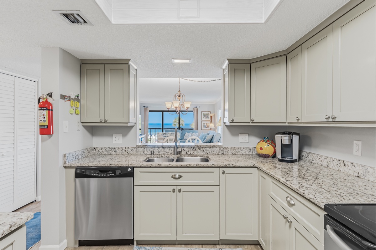 A bright, well-equipped kitchen with granite countertops and stainless appliances opens directly to stunning sea views, making every meal prep feel like a vacation.