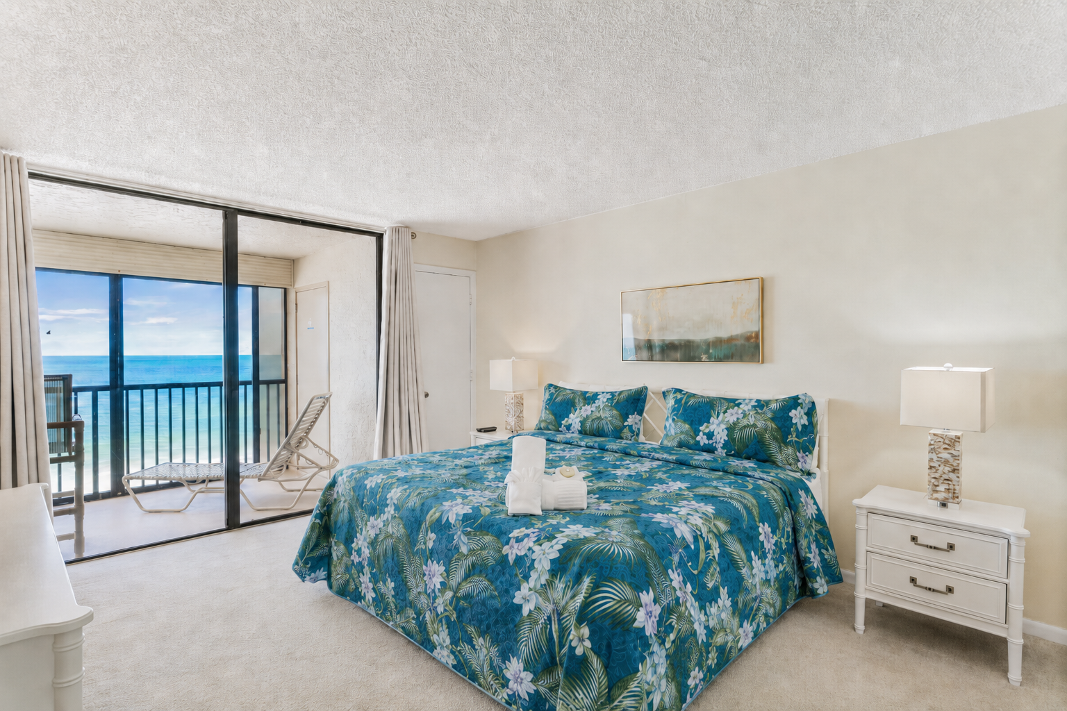 Drift off in this serene King bedroom with tropical bedding and direct balcony access to stunning ocean vistas—your personal coastal retreat awaits.