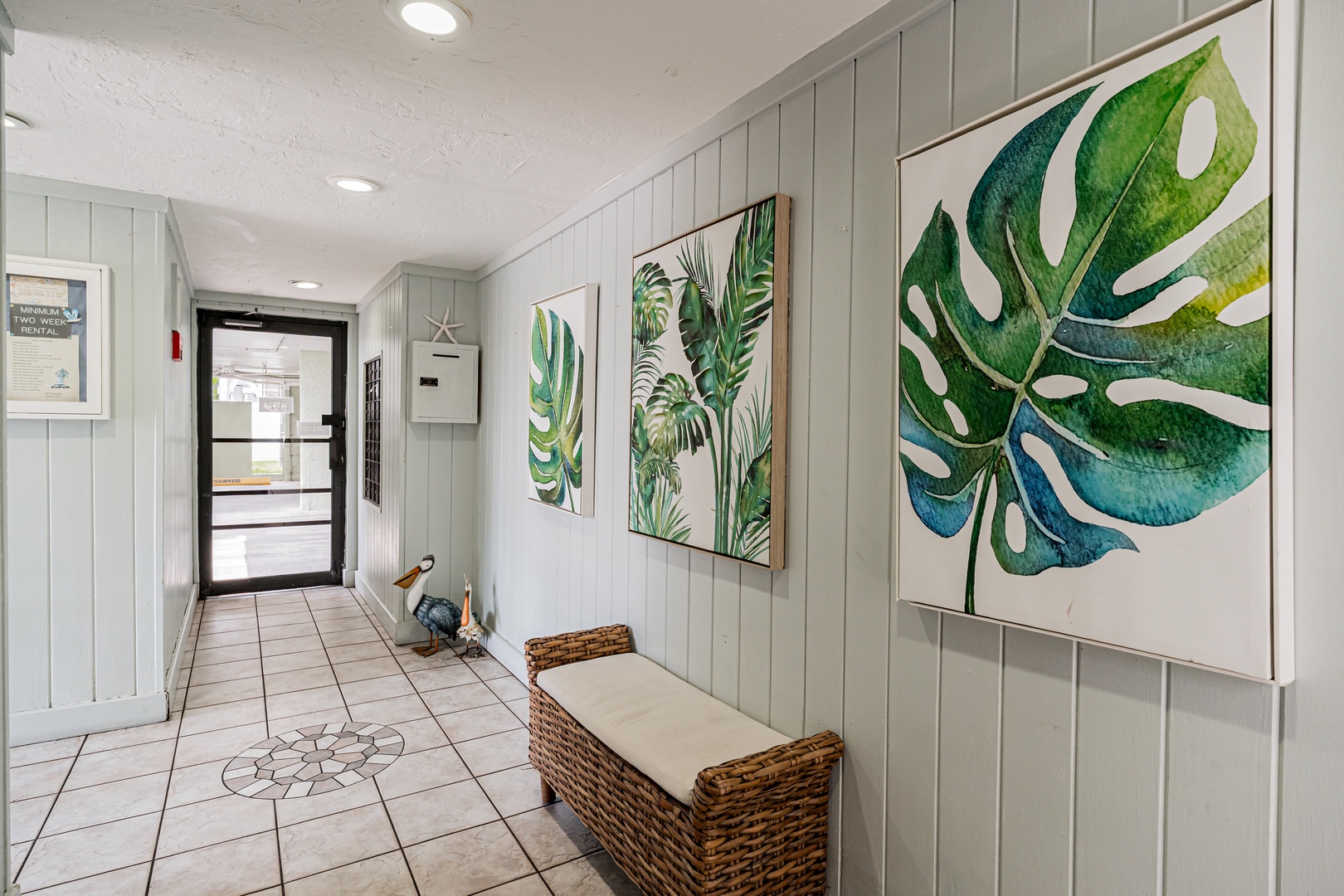 Step into a bright, welcoming entry adorned with tropical-inspired art. This serene hallway with coastal charm sets the tone for your relaxing getaway the moment you arrive.