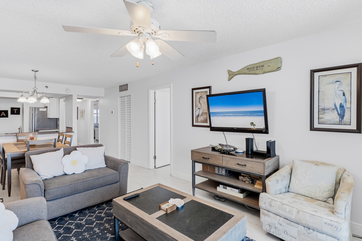 Unwind in your bright coastal living room with comfy seating and entertainment center, perfect for relaxing after beach days.