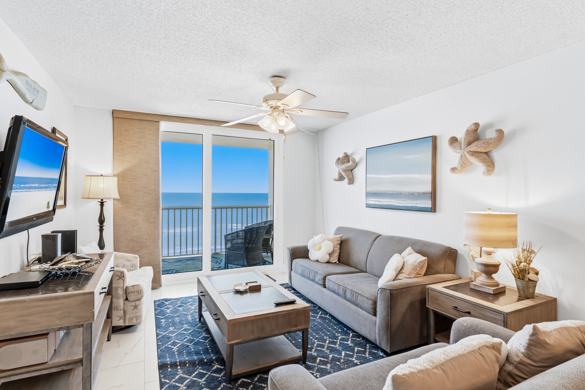 Your oceanfront living room features stunning sea views through floor-to-ceiling windows, where you can relax on plush seating while watching endless blue horizons.