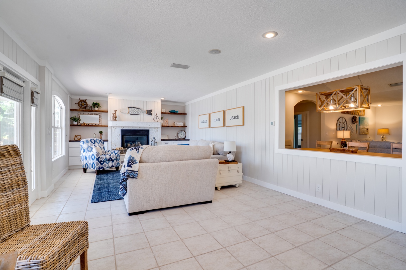 Relax in your bright coastal living room with comfortable seating, fireplace warmth, and charming nautical touches throughout.