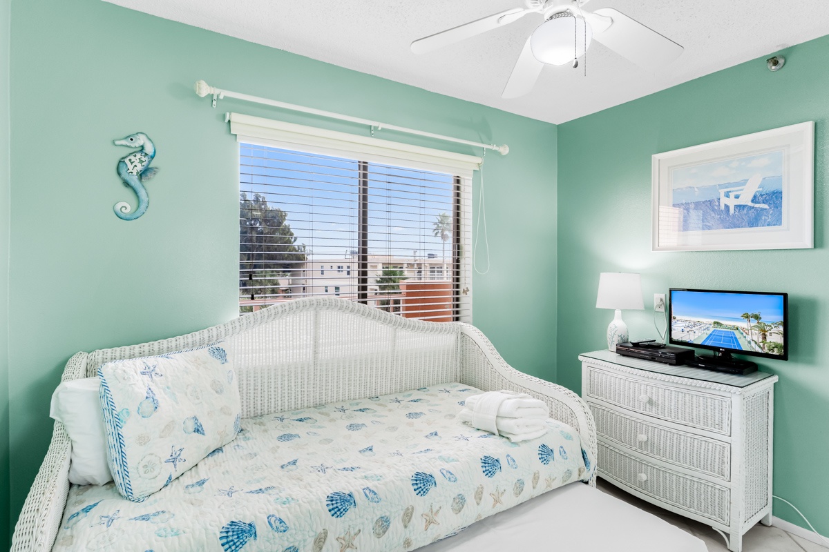Relax in your coastal-themed room with a cheerful daybed and soothing sea-green walls that create the perfect beach retreat.