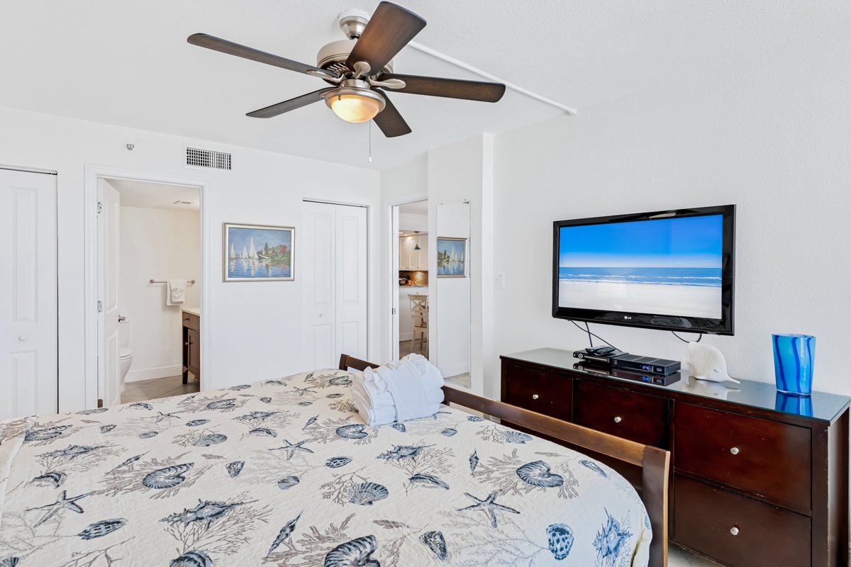 Drift off under the gentle breeze of your ceiling fan, while ocean scenes play on your flat-screen TV in this serene coastal-themed bedroom.