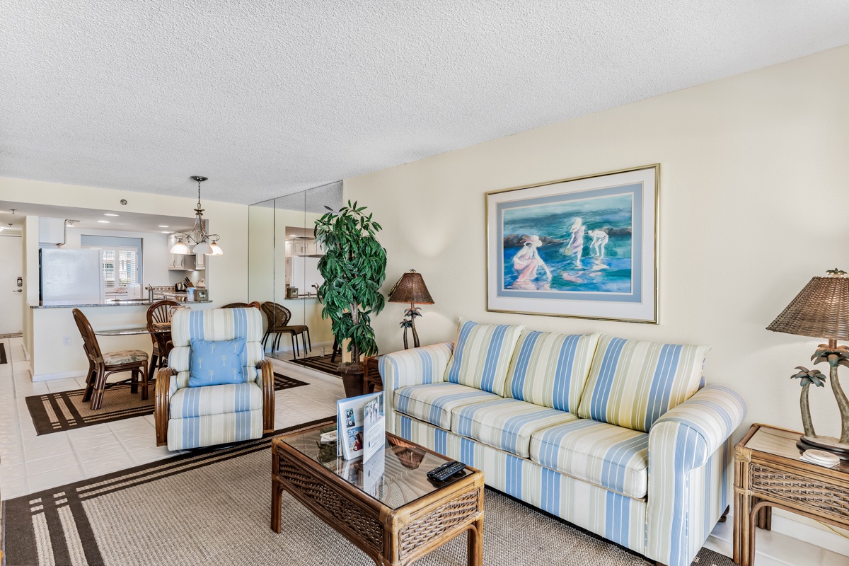 Step into your spacious open-plan living and dining area, where coastal charm meets home comfort. The breezy blue and white striped sofa invites you to relax while you enjoy the bright, airy ambiance throughout.