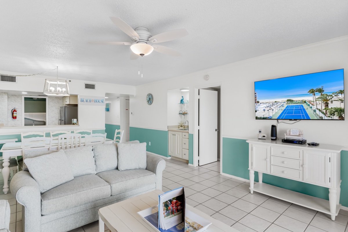 Relax in your bright coastal living room with soft seating and tropical charm, perfect for unwinding after beach adventures.