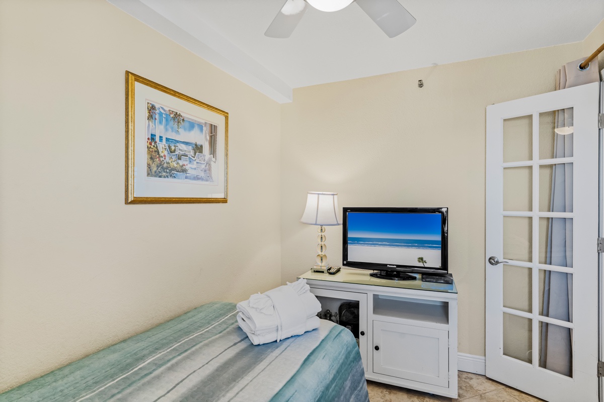 Relax in your cozy bedroom with beach vibes, complete with flat-screen TV and charming coastal artwork to set the perfect vacation mood.