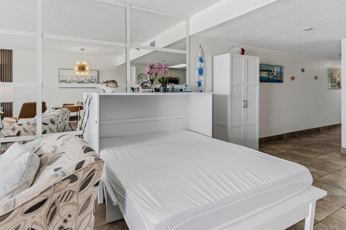 Step into this bright, airy condo where coastal charm meets comfort. Your open-plan space flows seamlessly from the cozy queen murphy bed to the dining nook and kitchen, all bathed in natural light and styled with beachy accents.
