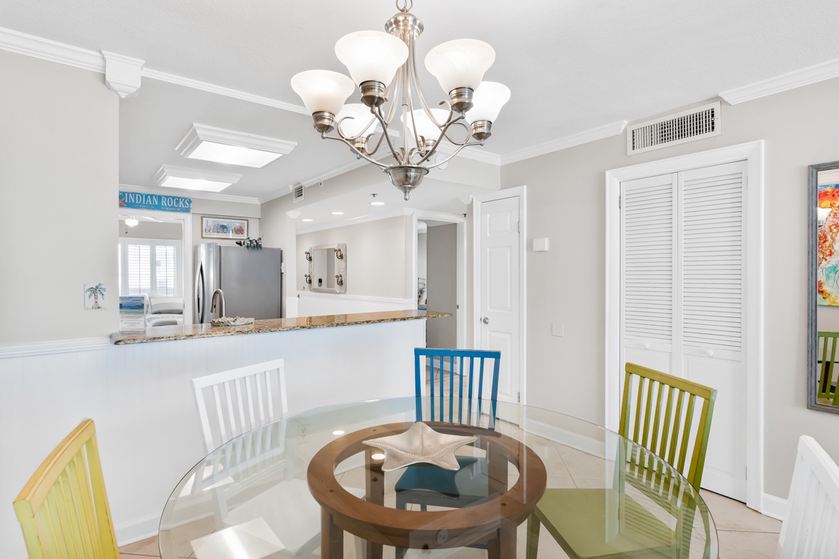 Gather around this elegant dining table where colorful chairs create a cheerful coastal vibe, perfect for sharing meals together.