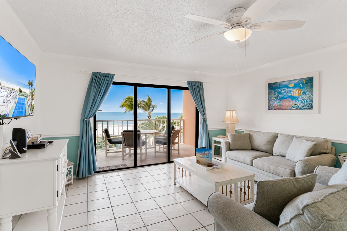 Relax in your bright living room with comfy seating, coastal decor, and sliding doors opening to your private balcony.