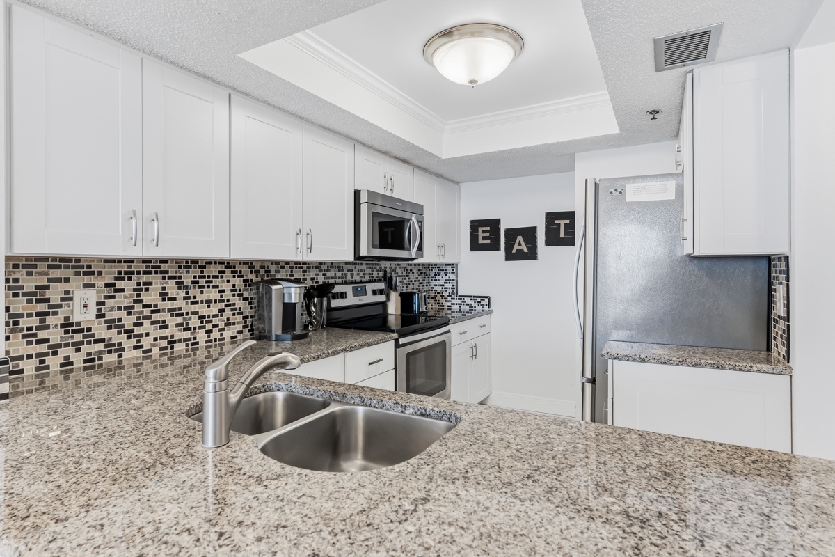 Your modern kitchen features granite counters, stainless appliances, and stylish tile backsplash - perfect for preparing meals during your stay.
