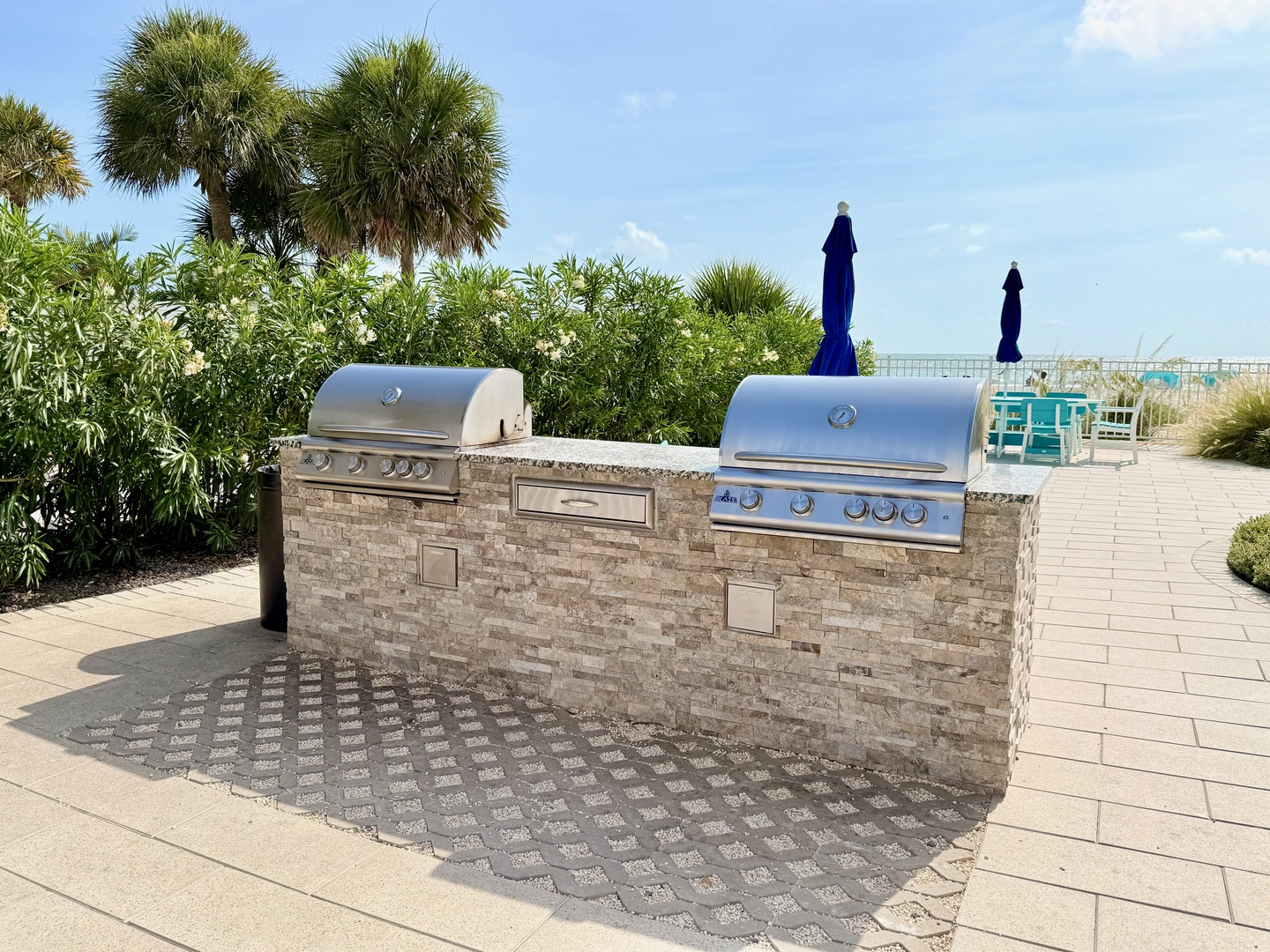 A well-equipped outdoor grilling station is steps from the beach, offering a perfect spot to prepare fresh meals while enjoying the coastal breeze and palm-dotted surroundings.