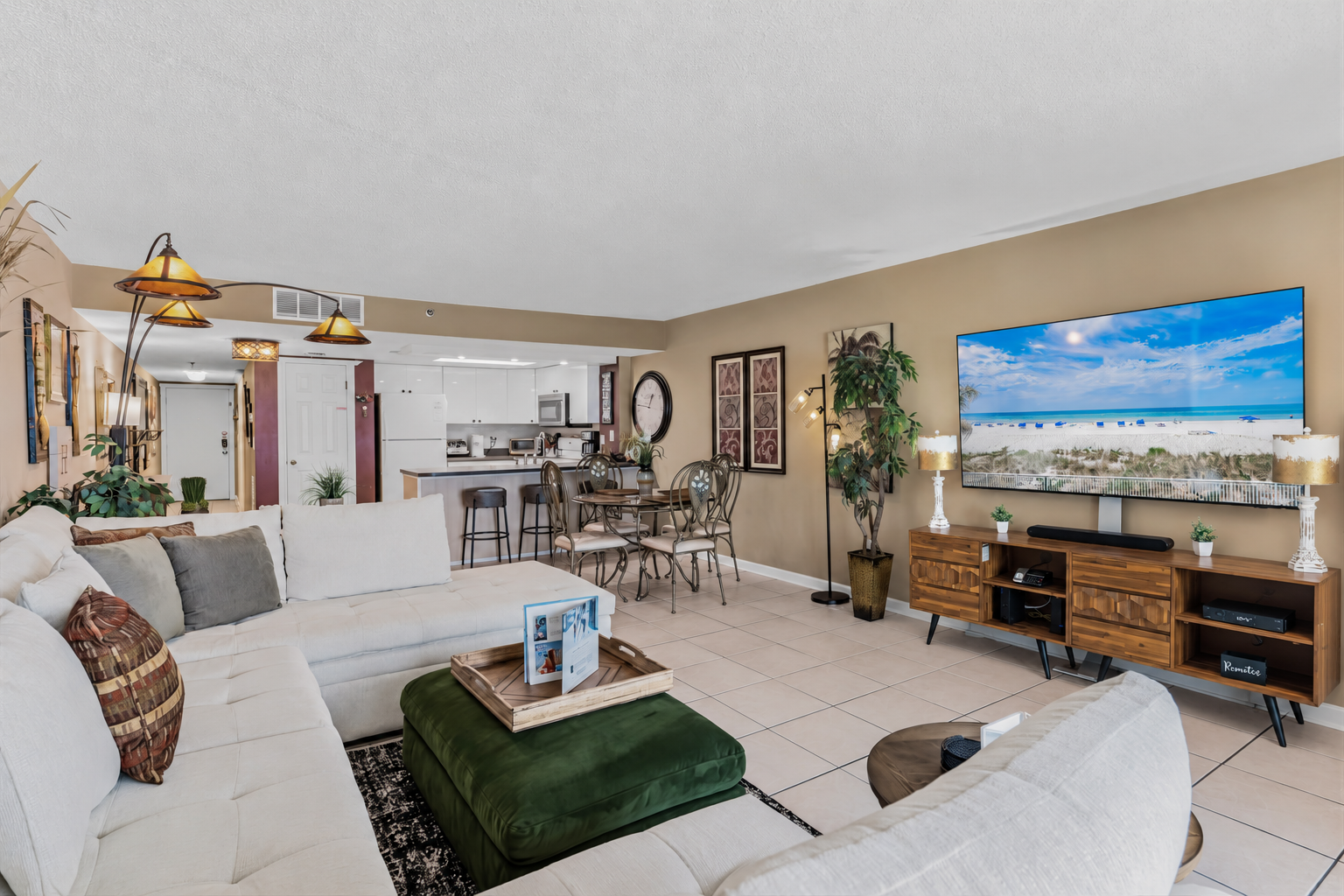 Relax in your spacious, light-filled living area with comfortable seating, ocean-inspired décor, and open-plan kitchen—perfect for unwinding after beach adventures.