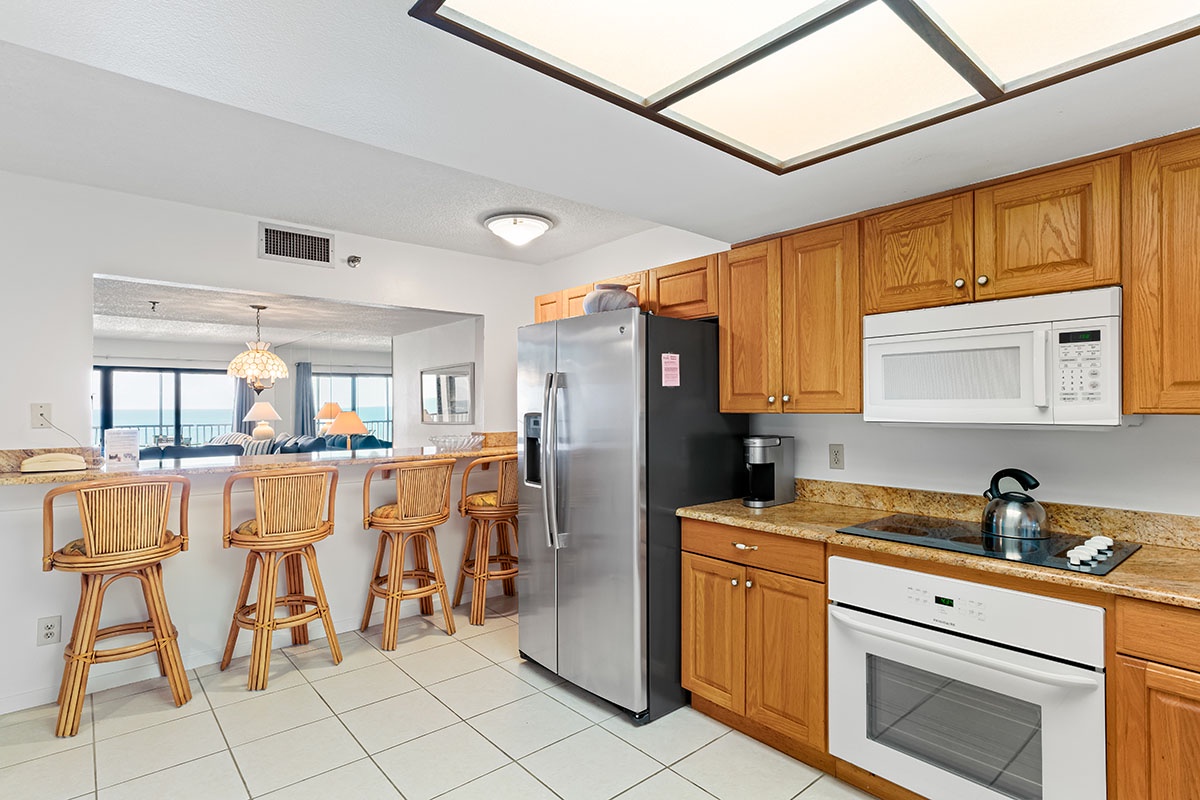 Your spacious kitchen flows seamlessly into the dining area, featuring warm wood cabinetry and modern appliances for effortless meal preparation.