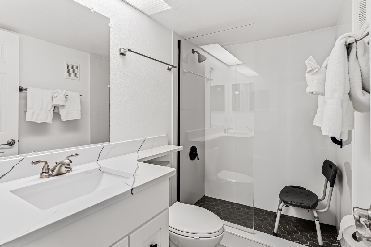 Step into a bright, modern bathroom designed with your comfort in mind. The spacious walk-in shower and fresh white towels invite you to refresh after a day of exploring.
