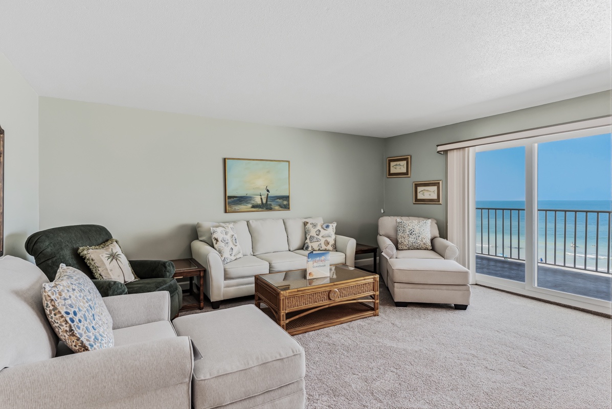 Unwind in your spacious living area with plush seating and a balcony door opening to stunning ocean views—your perfect coastal retreat.